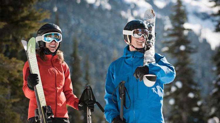 Couple dressed and equipped for snow skiing.