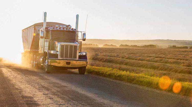 Farm truck driving past a field. 